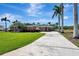 Single-story home featuring lush landscaping, mature palm trees, and a long private driveway at 5209 26Th W Ave, Bradenton, FL 34209