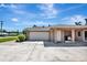 Spacious two-car garage with concrete driveway, side entrance, and cozy patio area at 5209 26Th W Ave, Bradenton, FL 34209