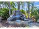 Beautiful rock waterfall feature surrounded by tropical plants, creating a tranquil outdoor oasis at 5209 26Th W Ave, Bradenton, FL 34209