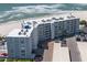 An aerial view of a beachfront condominium complex and parking area next to the ocean at 5300 Gulf Dr # 204, Holmes Beach, FL 34217