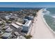Aerial view of condominium on beach near tennis court, storage units, residential area, shops and the bay at 5300 Gulf Dr # 204, Holmes Beach, FL 34217