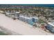 Aerial view of condo complex on beach with pool, tennis court, and lots of parking at 5300 Gulf Dr # 204, Holmes Beach, FL 34217
