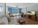 Comfortable living space features a sofa, coffee table, mounted TV and ocean views at 5300 Gulf Dr # 204, Holmes Beach, FL 34217