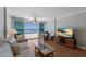 Cozy living room with hardwood floors, comfortable couch, and ocean views through large sliding glass doors at 5300 Gulf Dr # 204, Holmes Beach, FL 34217
