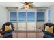 Bright sitting area showcases ocean view from two wicker chairs with striped pillows, hardwood flooring, and privacy at 5300 Gulf Dr # 204, Holmes Beach, FL 34217