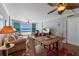 Comfortable living area features ocean view, a wooden dining table and a mounted flatscreen TV at 5300 Gulf Dr # 204, Holmes Beach, FL 34217