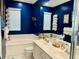 Bathroom featuring double sinks, a soaking tub, white tile, and decorative elements at 5360 Davini St, Sarasota, FL 34238