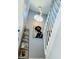 Stylish staircase with white railings, modern light fixture and unique wall art, enhancing the home's interior at 5360 Davini St, Sarasota, FL 34238