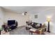 Cozy living room with a large TV, ceiling fan, and a comfortable sofa at 5727 25Th W St, Bradenton, FL 34207