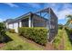 Exterior view of the screened lanai with manicured lawn and privacy landscaping at 6255 Cassia St, Bradenton, FL 34203