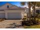 Charming single-story home features a two-car garage, landscaped front yard, and inviting entrance with beautiful palm trees at 6255 Cassia St, Bradenton, FL 34203