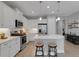 Bright kitchen features white cabinetry, stainless steel appliances, and a spacious island with seating for two at 6255 Cassia St, Bradenton, FL 34203