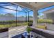 Covered lanai offers comfortable seating with view of manicured lawn and fence at 6255 Cassia St, Bradenton, FL 34203
