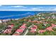 An aerial shot of a community with lush trees, red-tiled roofs, and serene waterfront views at 6407 Quail Hollow Pl, Bradenton, FL 34210