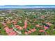 This aerial view displays red-tiled roofs and mature trees in a picturesque neighborhood near the golf course at 6407 Quail Hollow Pl, Bradenton, FL 34210
