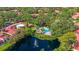 Aerial view showcases a community pool, pond and surrounding lush landscape at 6407 Quail Hollow Pl, Bradenton, FL 34210