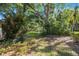 The serene backyard features mature trees and lush greenery, creating a private oasis at 6407 Quail Hollow Pl, Bradenton, FL 34210