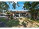 The rear exterior showcases sliding glass doors and lush landscaping for a serene and private setting at 6407 Quail Hollow Pl, Bradenton, FL 34210