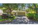 Charming single-Gathering home featuring a two-car garage and mature trees shading the front yard at 6407 Quail Hollow Pl, Bradenton, FL 34210