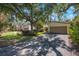 Charming single-Gathering home featuring a two-car garage and mature trees shading the front yard at 6407 Quail Hollow Pl, Bradenton, FL 34210