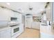 Open kitchen with white cabinets, modern appliances, and a view into the dining area at 6407 Quail Hollow Pl, Bradenton, FL 34210