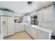 The open kitchen has a breakfast bar and modern white appliances at 6407 Quail Hollow Pl, Bradenton, FL 34210