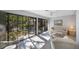 Bright living room with a couch, armchairs, and sliding glass doors to a lush garden at 6407 Quail Hollow Pl, Bradenton, FL 34210