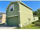 Green two-story home featuring an attached garage, white trim and green stucco at 7114 Hamilton Park Blvd, Tampa, FL 33615