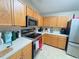 Well-lit kitchen featuring stainless steel appliances, light countertops, and wooden cabinetry at 7114 Hamilton Park Blvd, Tampa, FL 33615