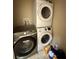Laundry room with stacked washer and dryer units, plus an additional washing machine for convenience at 7114 Hamilton Park Blvd, Tampa, FL 33615