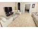 Bright and spacious living area with tile flooring, neutral walls, and an open doorway to another room at 7114 Hamilton Park Blvd, Tampa, FL 33615