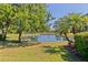 Backyard view of a lake surrounded by mature trees and green space at 7159 Westhill Ct, Lakewood Ranch, FL 34202
