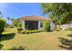 Backyard view with a screened lanai, tidy landscaping, and a red tiled roof at 7159 Westhill Ct, Lakewood Ranch, FL 34202