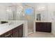 Dual sink bathroom with tiled shower, glass door, and dark wood cabinets at 7159 Westhill Ct, Lakewood Ranch, FL 34202