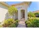 Charming front entrance with arched doorway, brick walkway, and manicured landscaping at 7159 Westhill Ct, Lakewood Ranch, FL 34202