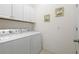 Bright laundry room with washer and dryer, plus overhead cabinets for storage at 7159 Westhill Ct, Lakewood Ranch, FL 34202