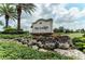 Landscaped entrance to The Lodge at Lakewood Ranch Golf and Country Club under a partly cloudy sky at 7709 Hazeltine Gln, Lakewood Ranch, FL 34202