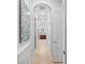 Hallway view of the primary bath with tiled floors and decorative archways at 7709 Hazeltine Gln, Lakewood Ranch, FL 34202