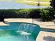Beautiful outdoor pool with a decorative waterfall feature and lush greenery in the background at 7709 Hazeltine Gln, Lakewood Ranch, FL 34202