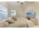 Bedroom showcasing a bed with accent pillows, a ceiling fan, and a flatscreen TV on a wooden console at 7710 Lake Vista Ct # 407, Lakewood Ranch, FL 34202