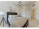 Bedroom with a modern chandelier, a dark wood bed frame, and a stylish side table with a lamp at 7710 Lake Vista Ct # 407, Lakewood Ranch, FL 34202