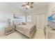 Cozy bedroom featuring a ceiling fan, a decorative headboard, and beach-themed decor at 7710 Lake Vista Ct # 407, Lakewood Ranch, FL 34202