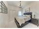 Bedroom showcasing a dark wood bed frame, a chandelier, and a grid-style mirror at 7710 Lake Vista Ct # 407, Lakewood Ranch, FL 34202