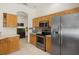 Modern kitchen featuring stainless steel appliances, tile floors, light wood cabinets, and breakfast bar seating at 8271 47Th Street E Cir, Palmetto, FL 34221