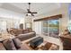 Bright living room with large sliding doors offering backyard and water views, tile floors, and a ceiling fan at 8271 47Th Street E Cir, Palmetto, FL 34221