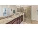 Modern bathroom featuring dual sinks, granite countertops, and a walk-in shower at 10072 Cozy Grove Dr, Venice, FL 34293