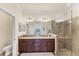 Elegant bathroom featuring dual sinks, granite countertops, and a glass-enclosed shower at 10072 Cozy Grove Dr, Venice, FL 34293