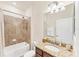 Well-lit bathroom featuring a shower-tub combo, granite counters, and ample storage space at 10072 Cozy Grove Dr, Venice, FL 34293