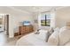 Bright bedroom featuring a neutral palette, large window, and wood dresser at 10072 Cozy Grove Dr, Venice, FL 34293
