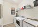Functional laundry room equipped with modern washer, dryer, utility sink, and storage shelving at 10072 Cozy Grove Dr, Venice, FL 34293
